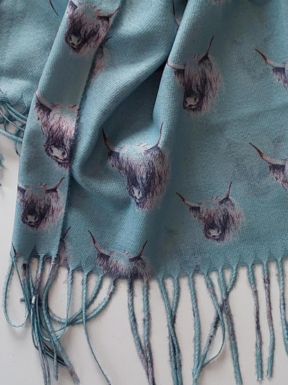 Sage scarf with highland cow pattern and fringes on a white background