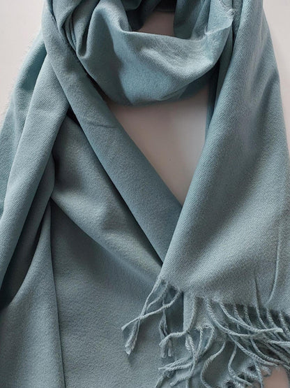 Green pashmina with tassels on a white background