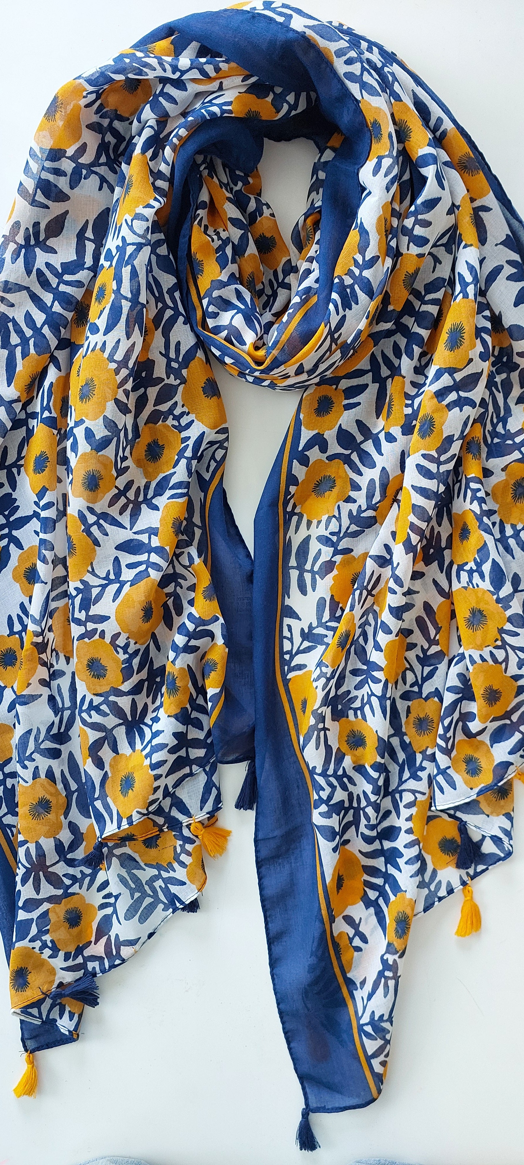 Blue and yellow floral patterned scarf with tassels on a white background