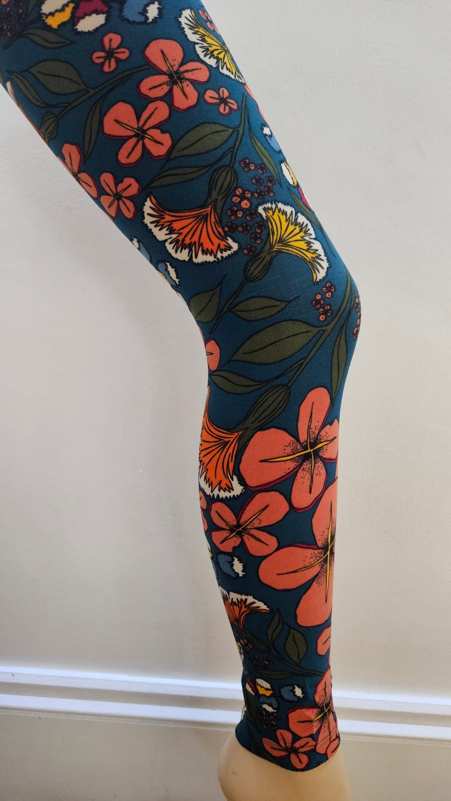 Floral-patterned leggings on a mannequin leg against a white background