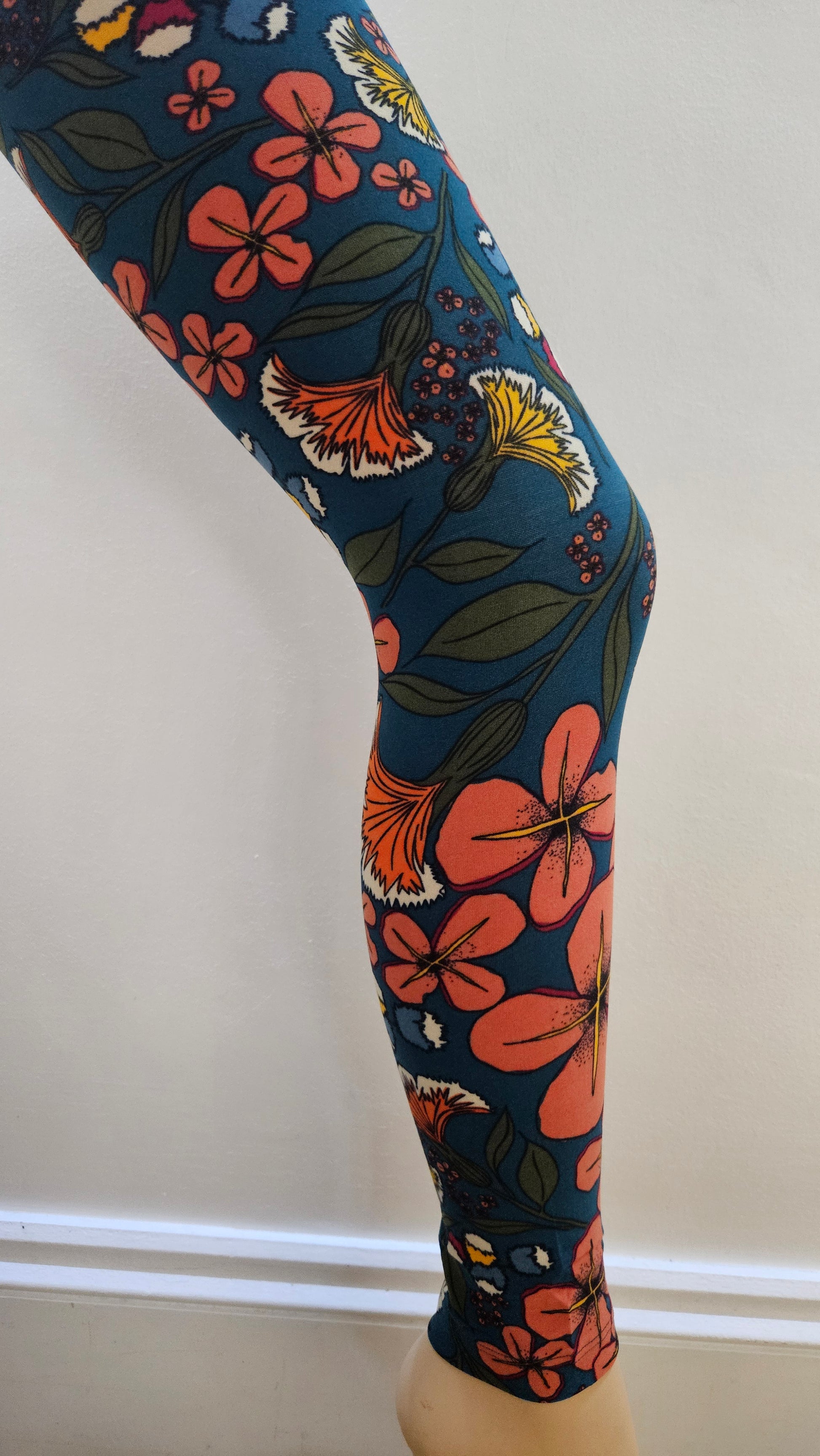 Floral-patterned leggings on a mannequin leg against a white background