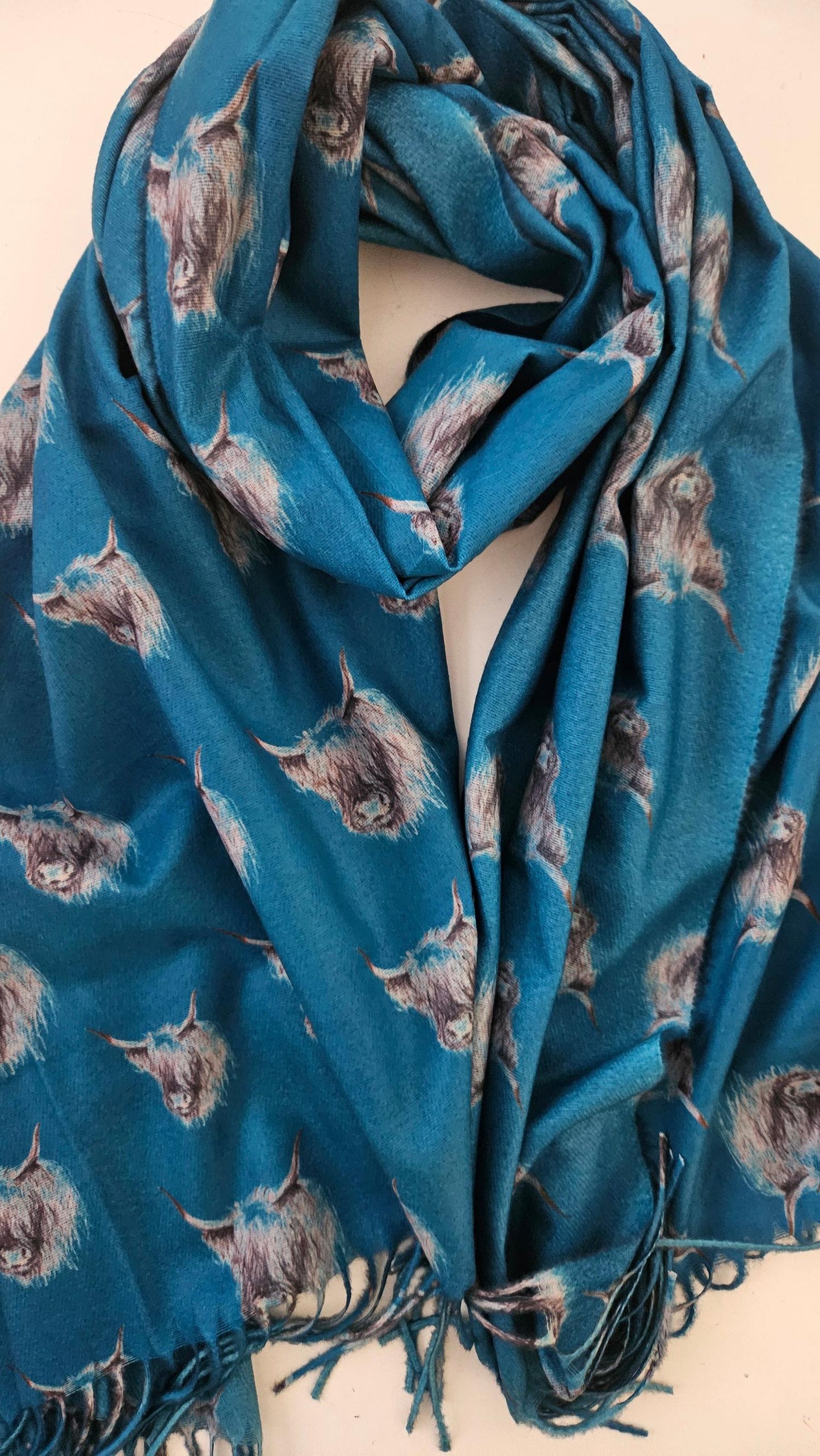 Blue pashmina with black and white highland cow pattern on a white background