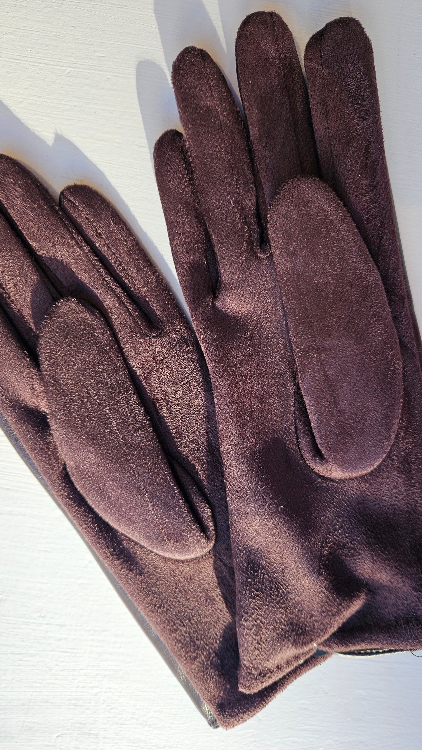 Underneath the brown leatherette gloves by Shimena on a white background