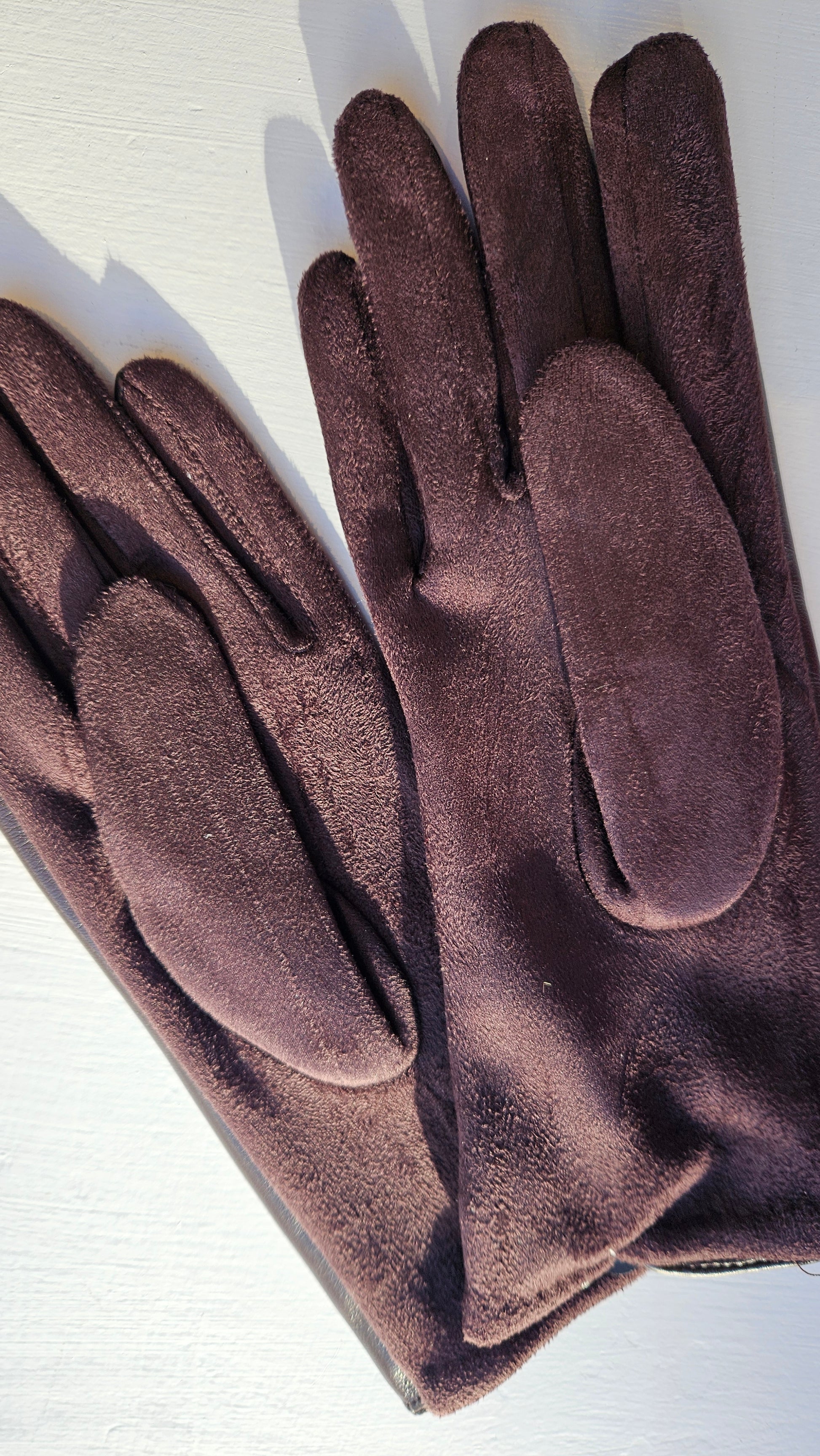 Underneath the brown leatherette gloves by Shimena on a white background