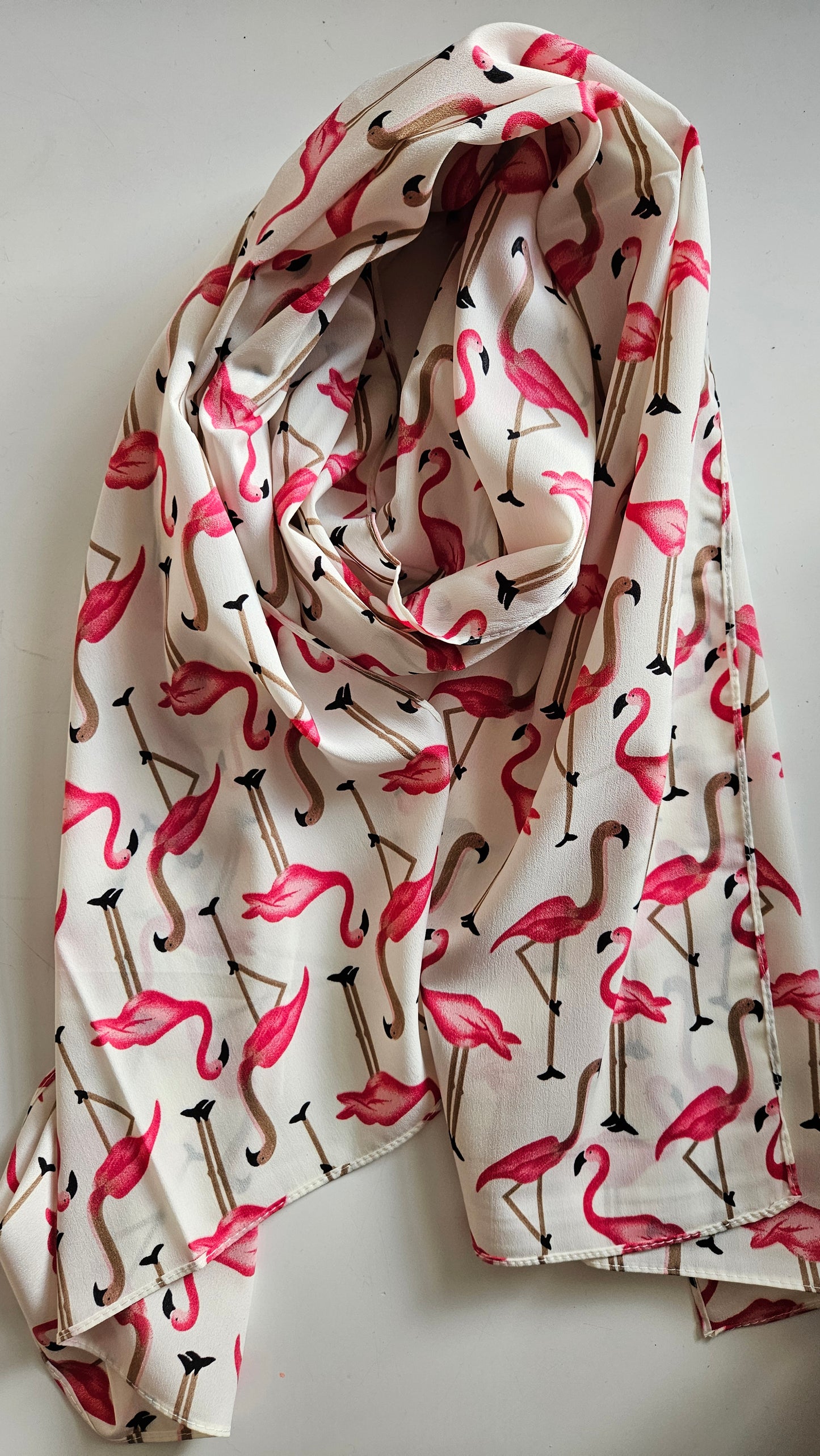 White scarf with flamingo pattern on a white background