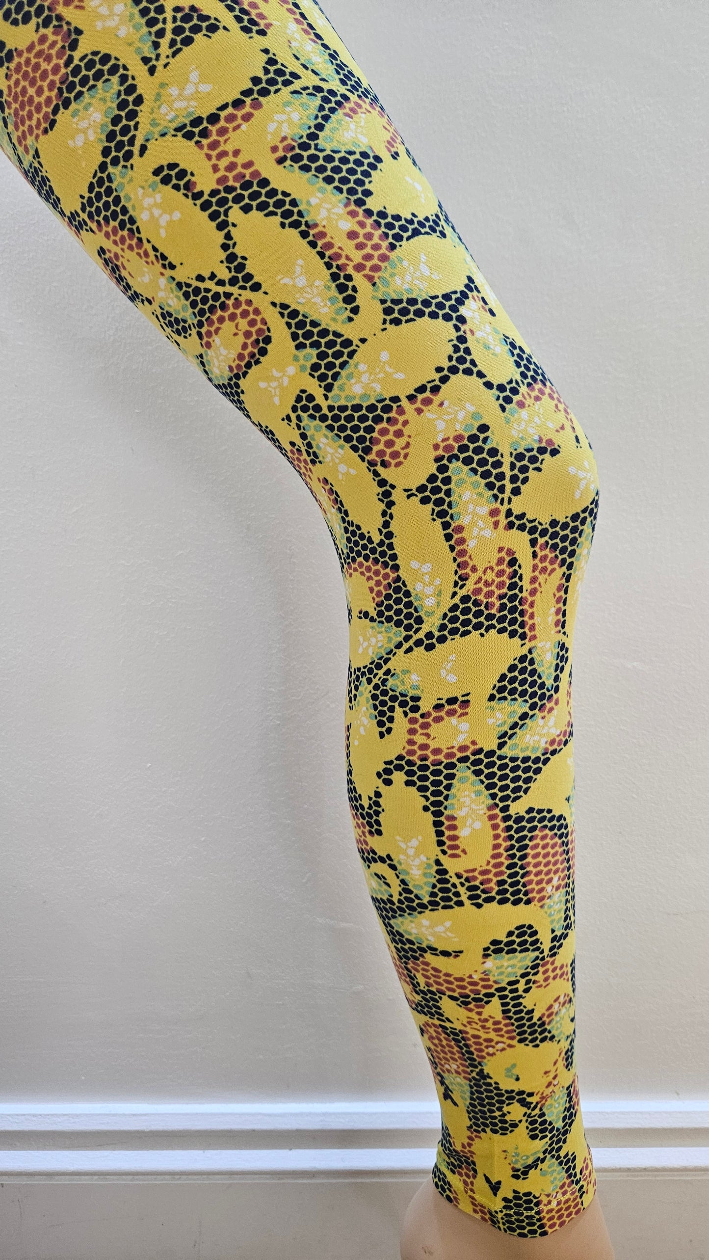 Yellow and black patterned leggings on a white background
